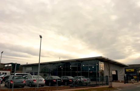 Flaches Gewerbegebäude mit Glasfassade in der Abenddämmerung